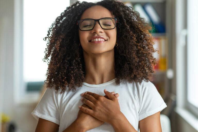 women holding her chest as if she’s praying.